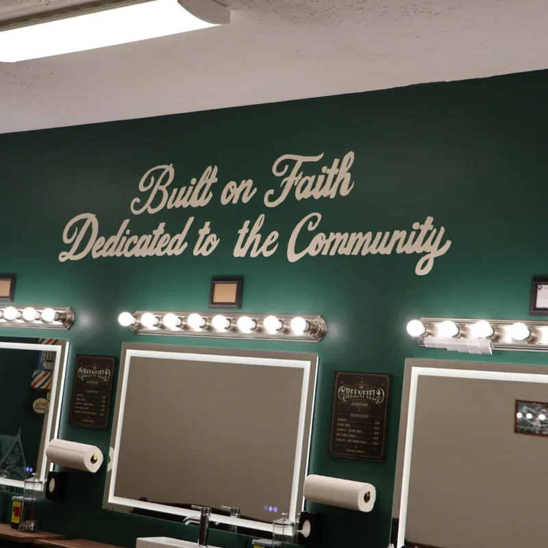 Cream script lettering on the green wall reading Built on Faith, Dedicated to the Community