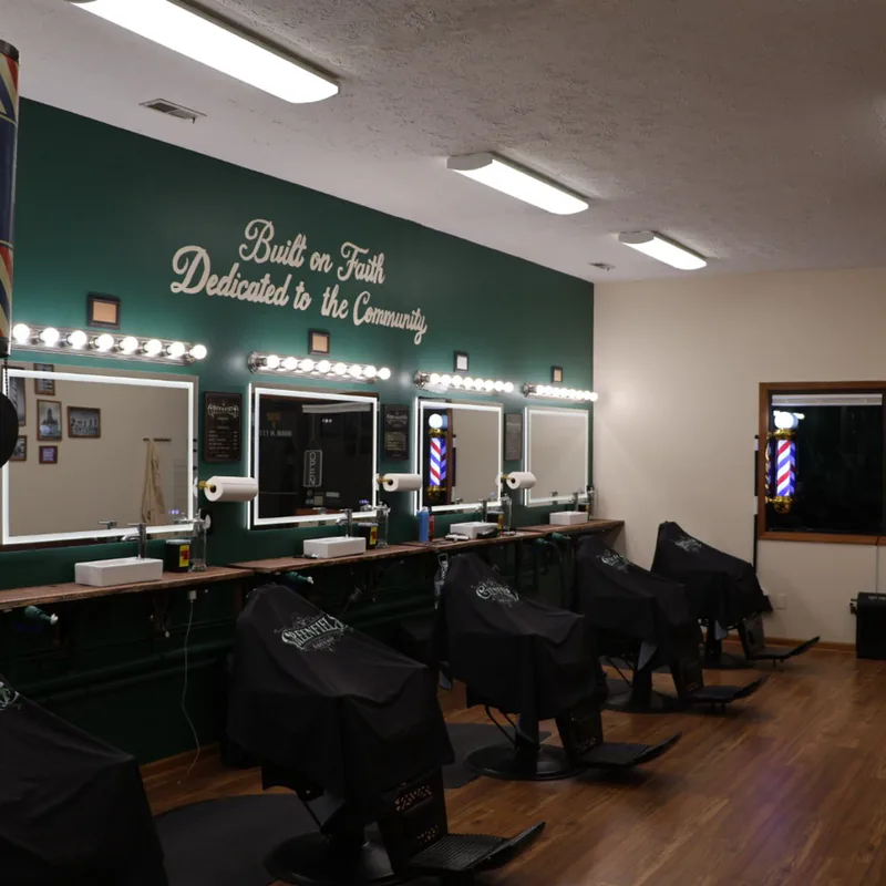 Four barber chairs lined up beneath the Built on Faith lettering